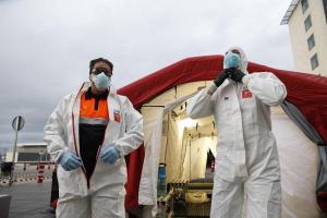 Trabajadores de proteccion civil se desinfectan contra el coronavirus en una carpa instalada en el hospital del PTS de Granada.