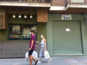 Una pareja, con mascarillas, en una barriada de la capital.