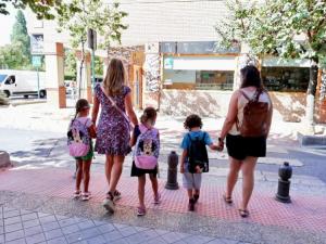 Tres alumnos con sus madres Tres escolares, con sus madres, se dirigen a su centro escolar en la capital.