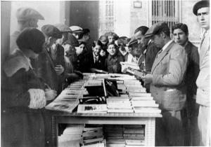 Público alrededor de un puesto de libros en Zaragoza durante la Fiesta del Libro de 1931.