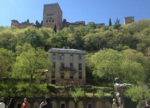 El Hotel Reúma, con la Alhambra al fondo, una estampa del Paseo de los Tristes y de Granada.