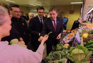 El ministro Luis Planas coge un espárrago verde de la Vega en uno de los puestos de Merca 80.