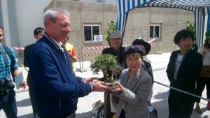 El presidente del Puerto entrega un bonsái a una de las supervivientes de Hiroshima.