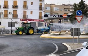 Un tractor agrícola en labores de desinfección de calles. 