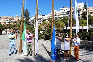 Izado de las banderas en la Playa de Puerta del Mar. 