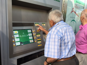 Un usuario saca su billete en la máquina expendedora.