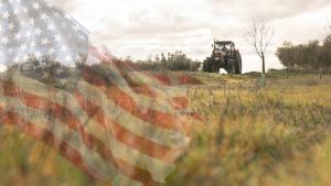 Un tractor en el campo, con la bandera estadounidense sobreimpresionada. 