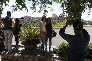 Turistas se hacen fotos con la Alhambra de fondo.