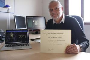 El profesor de la UGR Carlos Ureña Almagro posa en su despacho con el diploma de los Emmy que ha recibido.