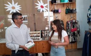 El delegado de la Junta entrega bonos descuento en una tienda de Huéscar.