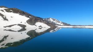 Reflejo de las montañas de Sierra Nevada aún medio nevadas sobre la laguna de las Yeguas. 