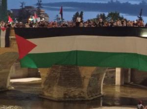 Una gran bandera palestina cuelga del puente nazarí.