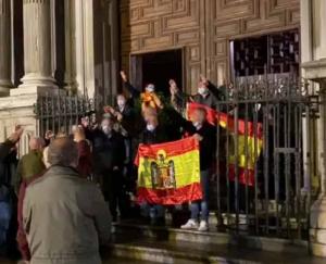 A las puertas del templo, brazo en alto, cantan el 'Cara al sol'.