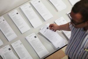 Un elector observa las papeletas en un colegio de Granada capital.