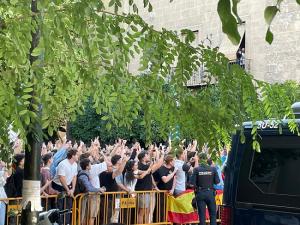 Los seguidores del 'influencer' de extrema derecha, móvil en mano, en la Plaza de la Universidad. 