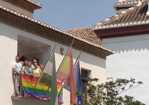 La alcaldesa, junto a integrantes de su equipo de gobierno, en el balcón del Ayuntamiento con la bandera Arco Iris.