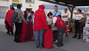 Voluntariado de Cruz Roja presta asistencia a un grupo de migrantes, entre ellos varios menores.