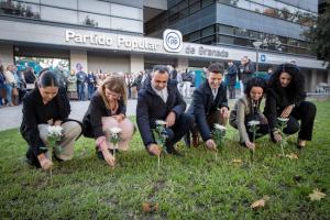 Dirigentes del PP de Granada colocan flores sobre el césped en recuerdo a las víctimas de la violencia machista.