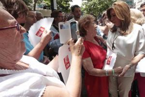 Susana Díaz conversa con una vecina en el Zaidín mientras otra le hace una foto.