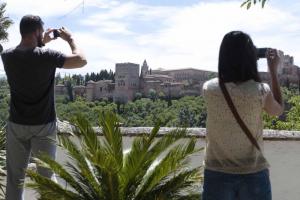 Unos turistas fotografían a la Alhambra desde el mirador de San Nicolás.